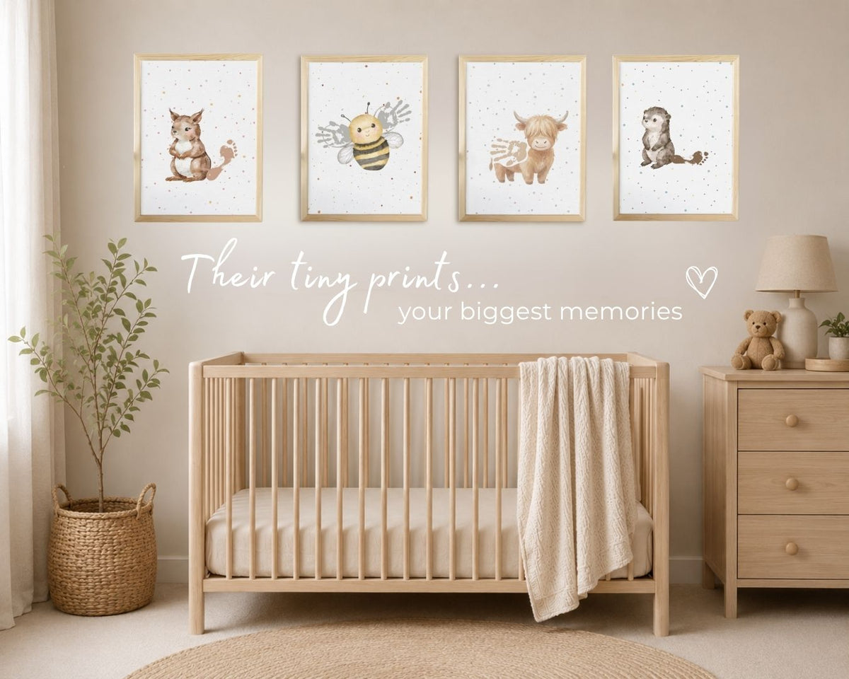 A styled nursery scene with four framed animal watercolor prints hanging above a light wood crib. The prints show a squirrel, a bee, a cow, and a otter on a speckled white background. Baby's hand and footprints complete the prints creating a personalised keepsake wall art display.