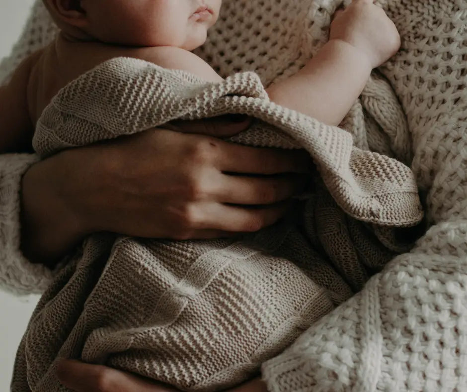Baby swaddled in beige blanket