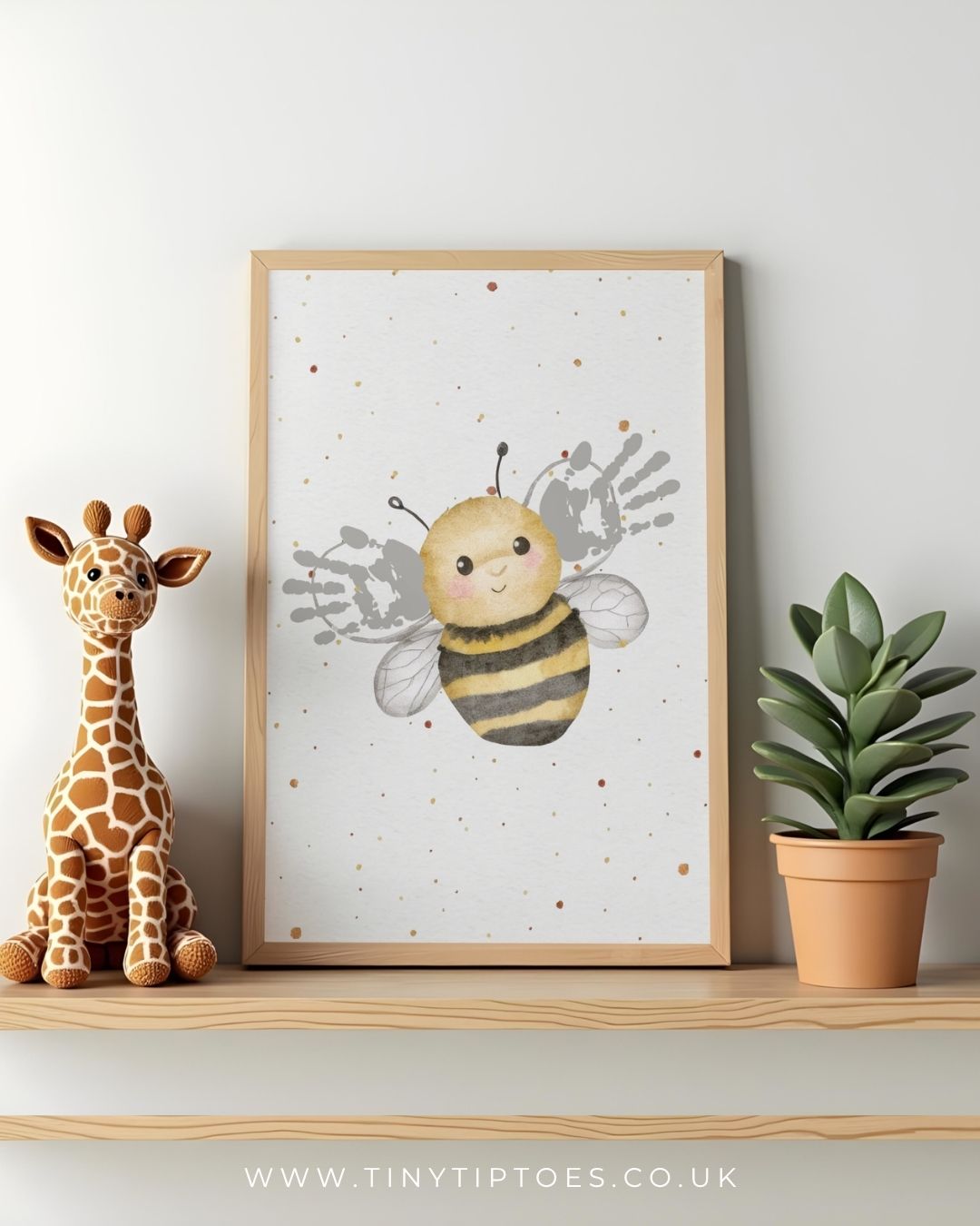Framed illustration of a bee with handprint wings in a baby's nursery