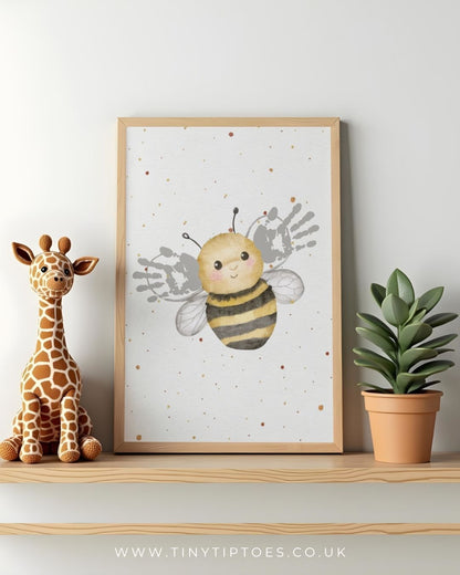 Framed illustration of a bee with handprint wings in a baby's nursery