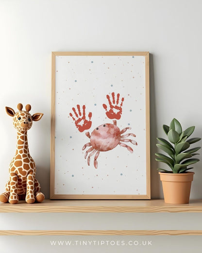 Framed crab artwork with handprints on a shelf with a toy giraffe and plant.