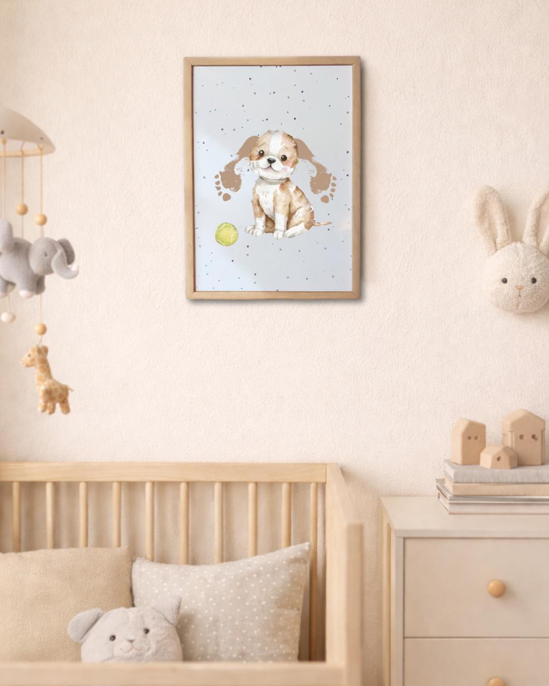 Framed children's poster of a dog on a wall above a cot with toys in a nursery. dog ears are made from baby footrpints