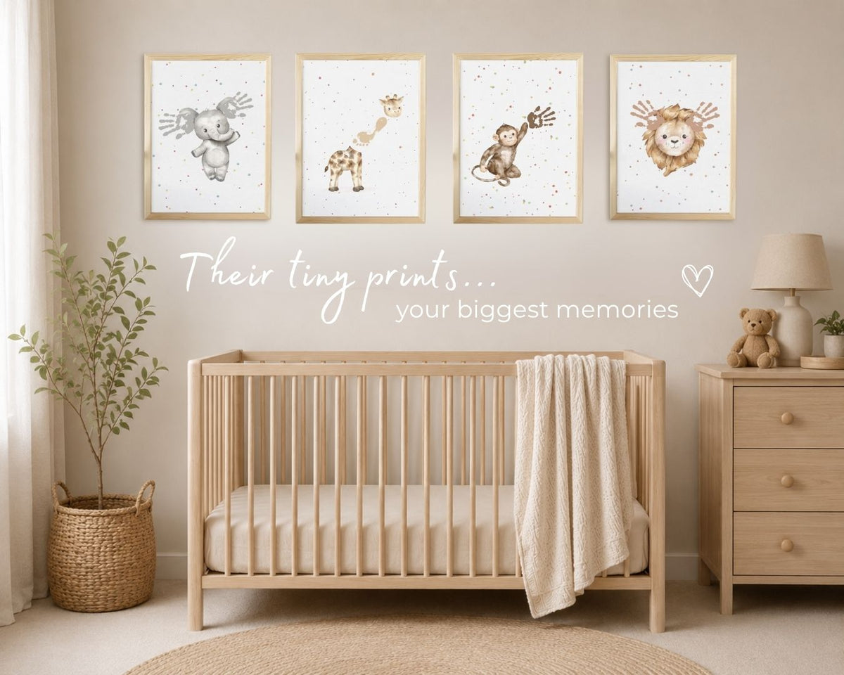 A styled nursery interior showing four framed animal prints on a beige wall above a light wood crib. The prints feature watercolor-style drawings of a bear, giraffe, monkey, and lion with baby's handprints and footprints.