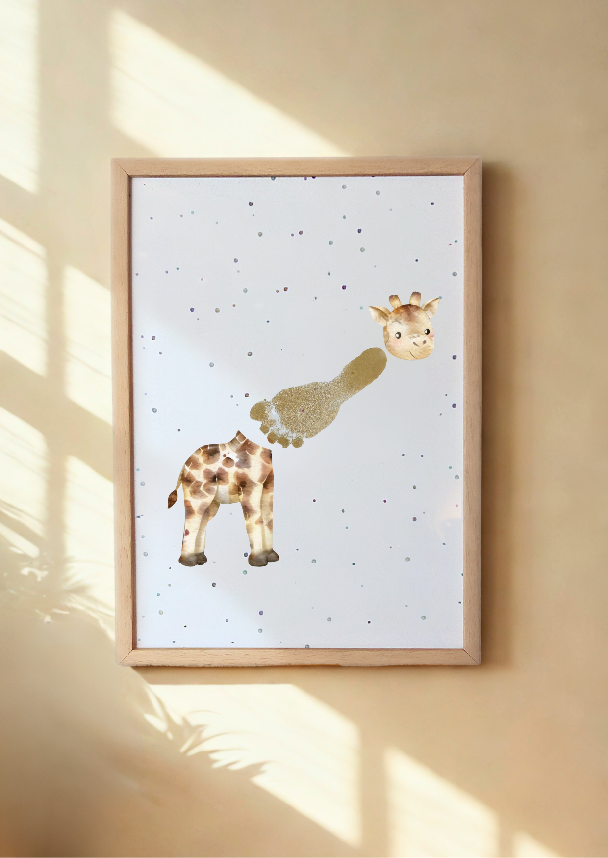Framed artwork of a giraffe on a light background, hanging on a wall. giraffe's neck is made from a baby's footprint