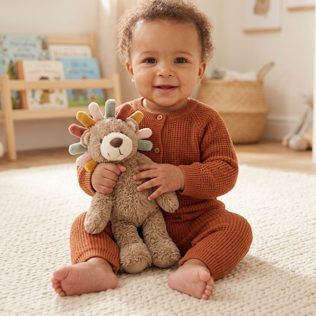 Child in a rust-colored outfit holding a plush toy lion in a room with a bookshelf and basket.