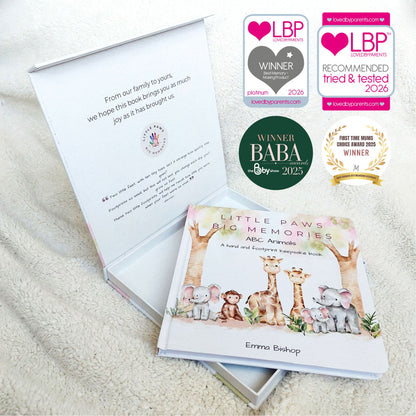 Children's book titled 'Little Paws Big Memories' with awards on a soft surface