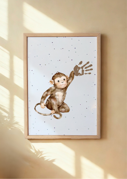 Framed artwork of a monkey on a white background with a wooden frame, hanging on a beige wall with baby's handprint