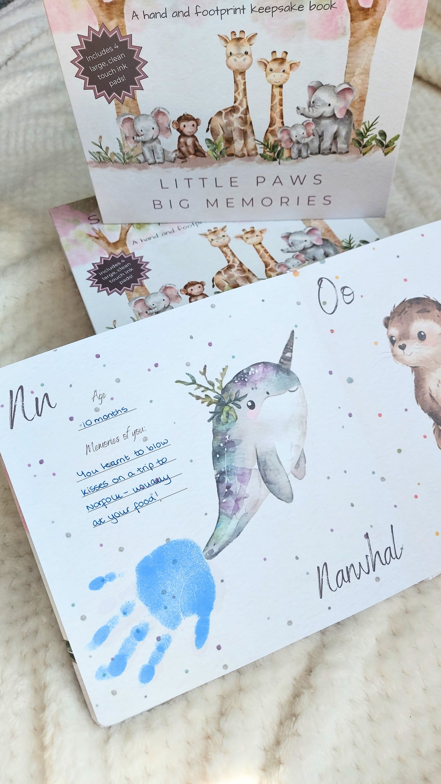 Children's book with animal illustrations and handprint and footprint designs on a textured surface.