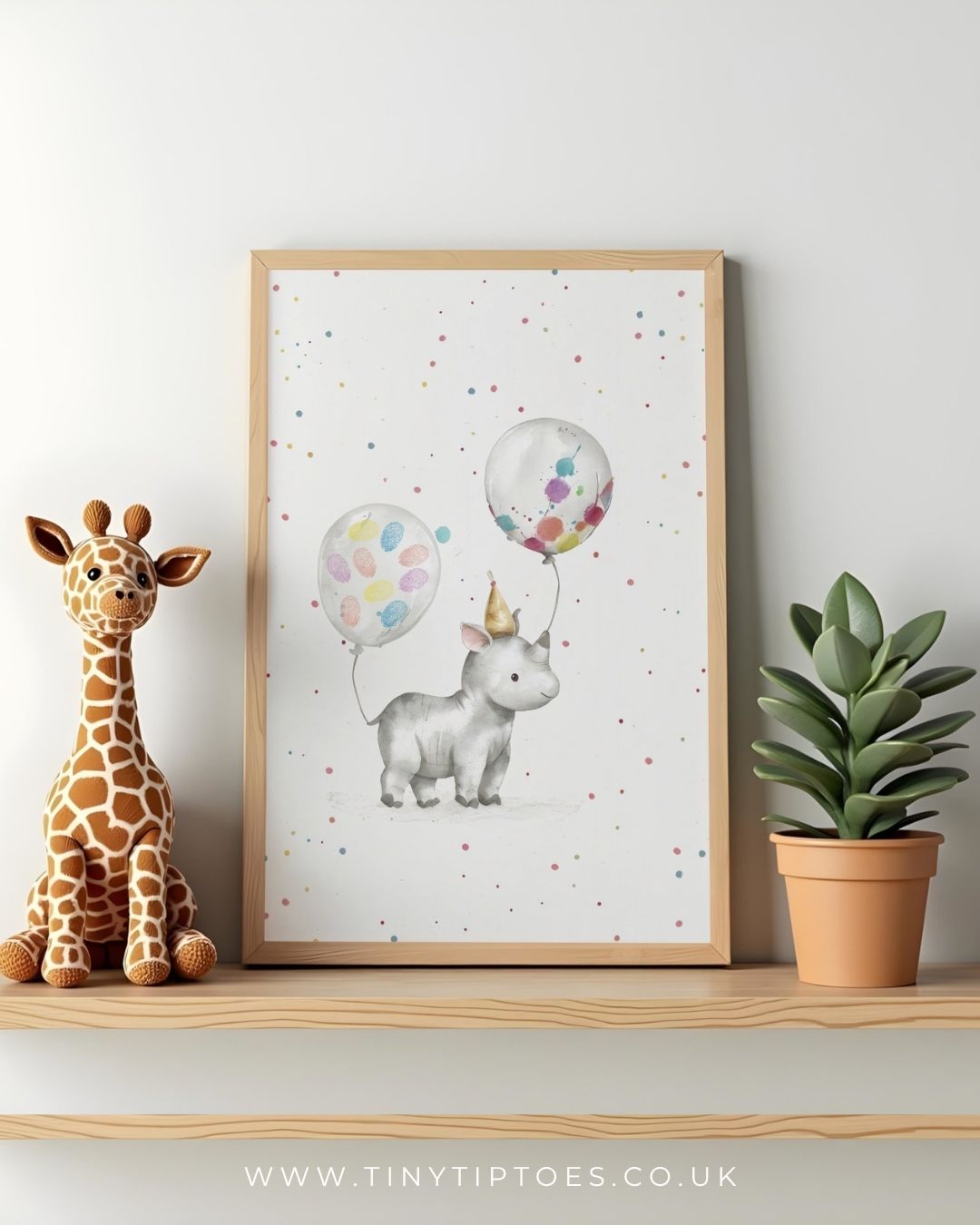 Framed children's illustration of a rhino with fingerprint balloons on a shelf with a toy giraffe and plant.