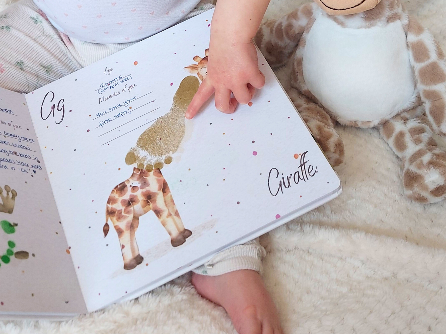 Child's hand holding a book with a giraffe illustration on a soft surface, footprint neck on giraffe