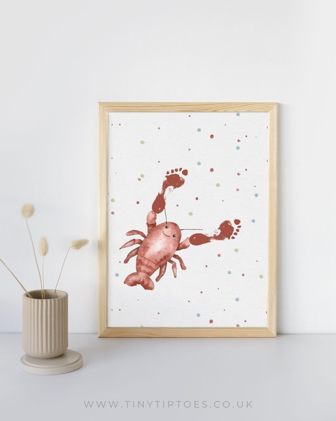 Framed illustration of a red yabby with footprint claws on a white background with colorful dots, next to a vase.