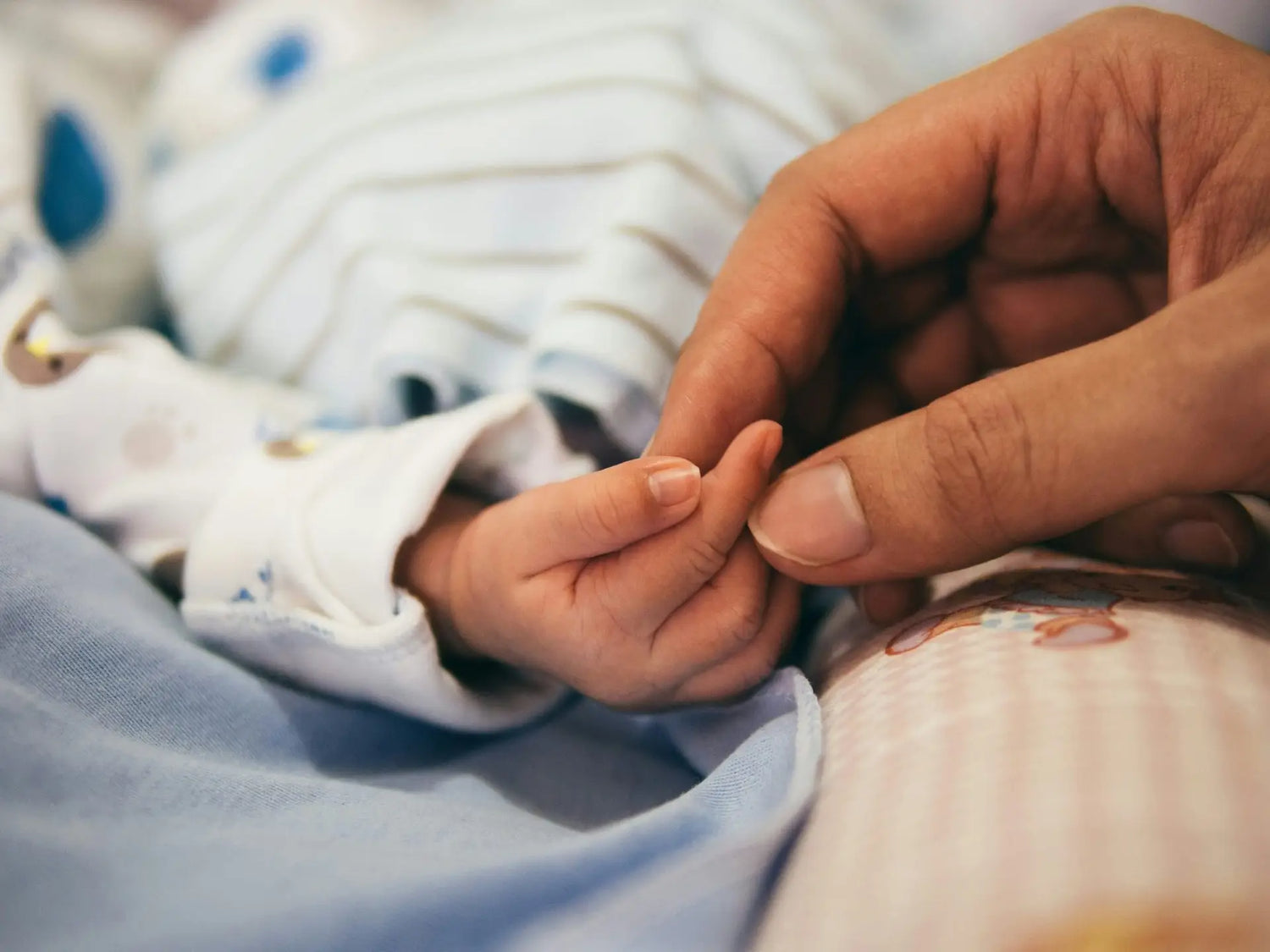 dad holding newborns hand