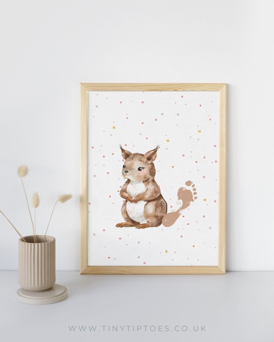 a framed illustration of a squirrel with a baby footprint tail on a white background