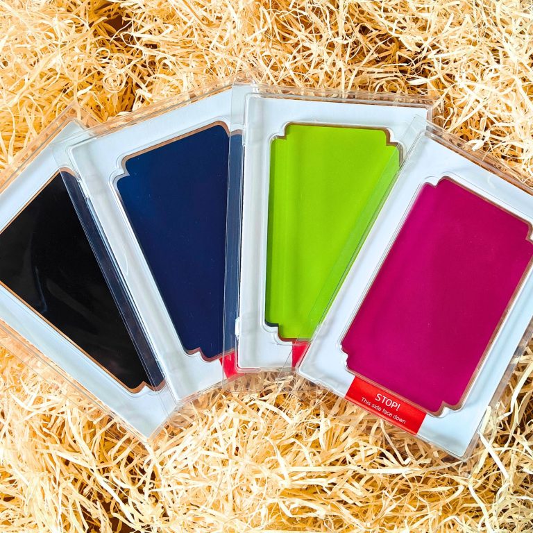 Set of 4 Clean Touch mess free ink pads - Black, Dark Blue, Light Green and Fuchsia for handprints and footprints. On a bed of straw
