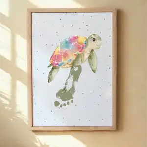 A framed print of turtle with a child's footprint as flipper