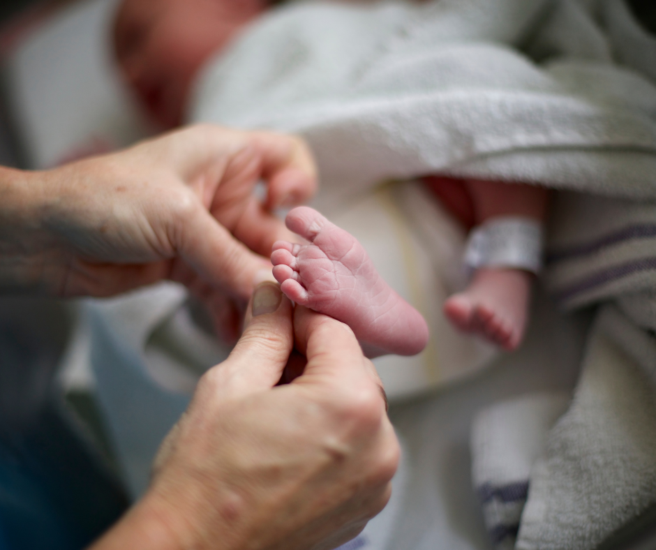 Adult holding newborn baby’s tiny feet – close-up newborn detail representing baby keepsake and memory moments